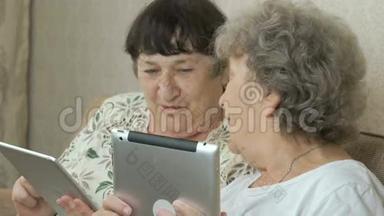 两位年迈的祖母手持数码平板电脑